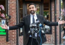 Celebrity Meltdown Exposes City Rot Man in a suit speaking at a press conference with microphones in front of him