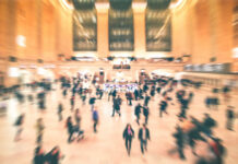System Meltdown: Heat Exposes NJ Transit Failures A busy train station filled with blurred figures of people moving
