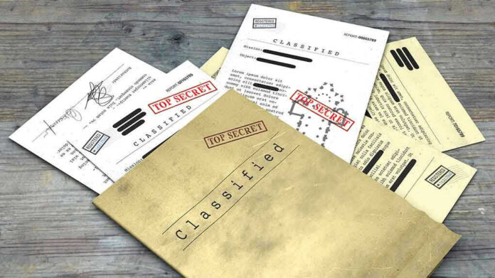 Classified documents with Top Secret stamps on wooden surface.