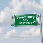 Sanctuary Push Ignites Law-and-Order Clash Green highway sign against cloudy sky