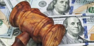 Wooden judge's gavel on scattered US dollar bills