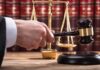 Republicans Move To Impeach Federal Judge Judge's hand holding gavel near scales of justice
