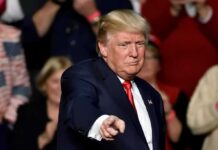Trump Just Revealed A Stunning Crime Shift man in suit pointing toward the camera at an event