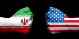 Fists painted as Iran and United States flags facing each other