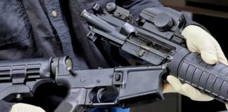 Person wearing gloves disassembling a rifle