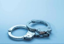 Trafficking Sting Expands During World Cup Metal handcuffs on a light blue surface