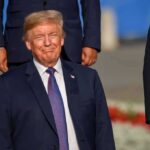 Trump Alliance Goes Further Than Anyone Knew smiling man in a navy suit at an outdoor event