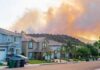 LEAVE NOW: California Town in Peril Suburban street with wildfire smoke over nearby hills