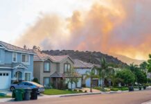 Suburban street with wildfire smoke over nearby hills