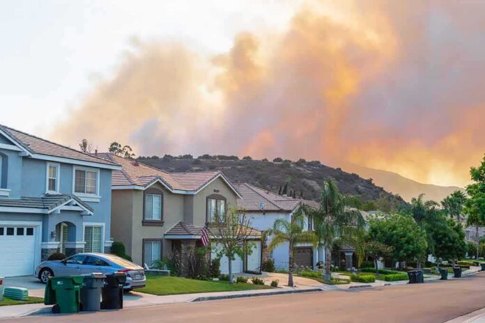 Suburban street with wildfire smoke over nearby hills