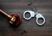 Hate Rampage Shocks LA Transit Judge's gavel and metal handcuffs on wooden table