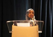 Deportation Showdown: Trump Targets Omar Woman in hijab speaking at a podium