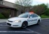 Police car with flashing lights parked outside a building
