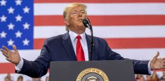 speaker at podium with U.S. flag backdrop