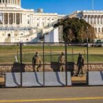 Power Grab? DOJ Muzzles D.C. On Troops Soldiers stand behind a security fence near a large government building
