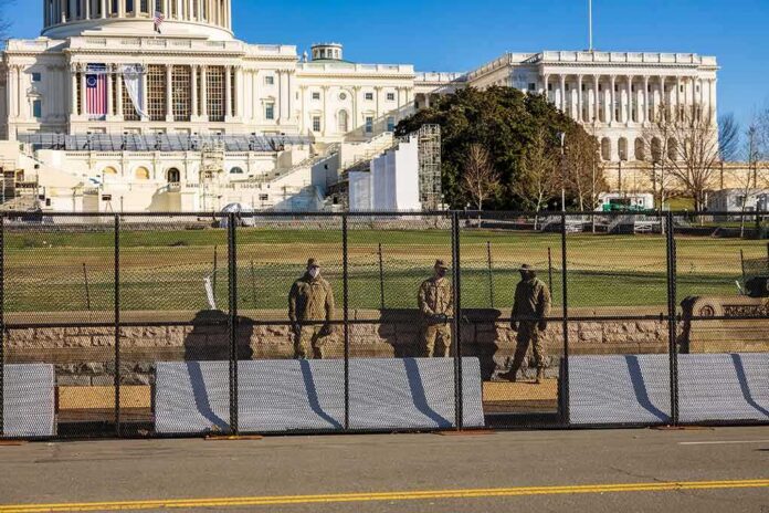 Soldiers stand behind a security fence near a large government building