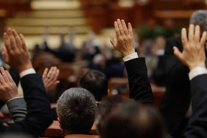 shutterstock_1919379413 Raised hands in a formal meeting or vote