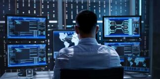 IT professional monitors multiple screens in a server room