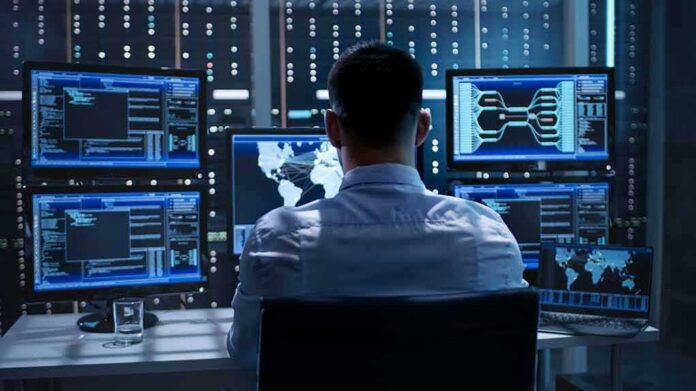 shutterstock_669226093 IT professional monitors multiple screens in a server room