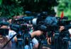 Federal Raid Exposes Ghost Truck Schools TV news cameras crowding together at an outdoor event
