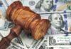 Wooden judge's gavel on scattered US dollar bills