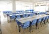 Hidden Villain Behind Teen Meltdowns Empty cafeteria with rows of blue chairs and long tables