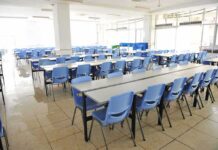 Hidden Villain Behind Teen Meltdowns Empty cafeteria with rows of blue chairs and long tables