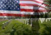 Army Doctor Digs Into 2,544 Deaths A military cemetery with white gravestones and an American flag overlay, featuring a soldier silhouette