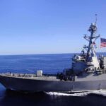 Eight Sailors Hit Breaking Point Naval destroyer sailing on open sea with flag flying