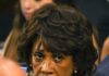 Inflation Blame Game Explodes In Hearing woman with serious expression in a crowd