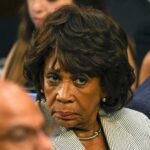 Inflation Blame Game Explodes In Hearing woman with serious expression in a crowd