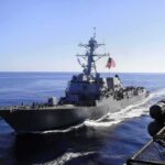 naval destroyer sailing at sea with flag flying