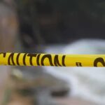 Students Teeter On Collapse Zone Yellow caution tape stretched across a blurred outdoor scene