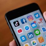 AI Child Abuse Ads Slip Through Meta Smartphone screen with social media and messaging apps