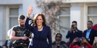 Kamala Harris waves to a crowd at an outdoor event