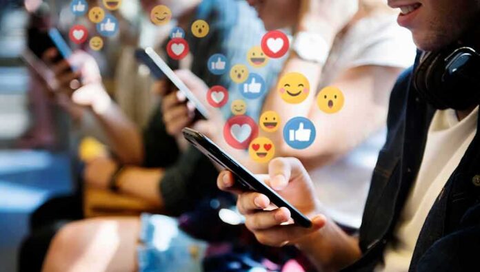 shutterstock_1338120284 people using smartphones with social media reactions