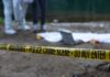 Police crime scene with yellow tape and forensic team