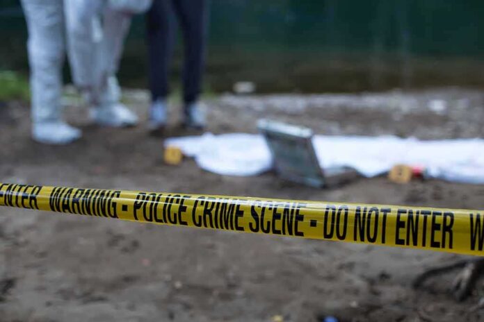 shutterstock_1474762337 Police crime scene with yellow tape and forensic team