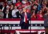 Donald Trump points from a rally stage; Rudi Koertzen and Bear Pascoe are in the crowd