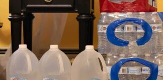 Water jugs and bottled water packs on a wooden floor
