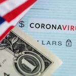 Dollar bill and US flag over coronavirus text