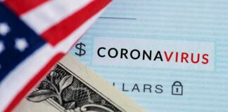 Dollar bill and US flag over coronavirus text