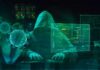 Hooded hacker at computer with digital virus graphics