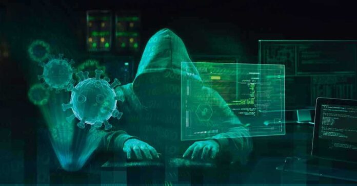 shutterstock_1700246950 Hooded hacker at computer with digital virus graphics