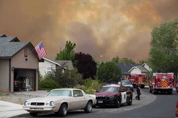 Emergency vehicles respond to wildfire near suburban homes