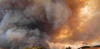 Wildfire smoke billows over suburban houses