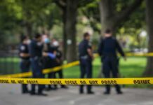 Gazebo Killing Sparks Rapid Arrest crime scene tape with police officers in a park
