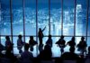 Antisemitism Firestorm Engulfs Mega Merger Business meeting with presenter pointing at city skyline through large windows