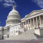 Blue Wave Crashes Into The Map The U.S. Capitol building with its dome and columns under a blue sky