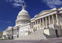 Blue Wave Crashes Into The Map The U.S. Capitol building with its dome and columns under a blue sky